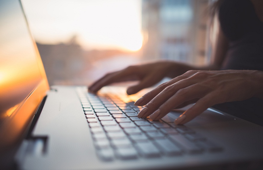 Woman working at home office hand on keyboard close up